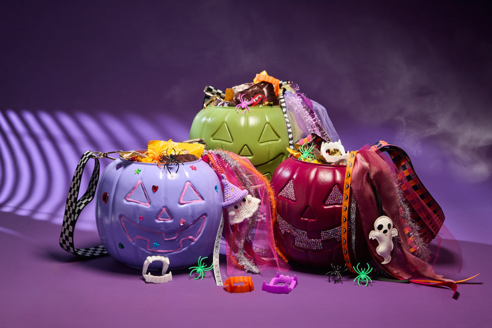 Three painted pumpkin purses on a purple background