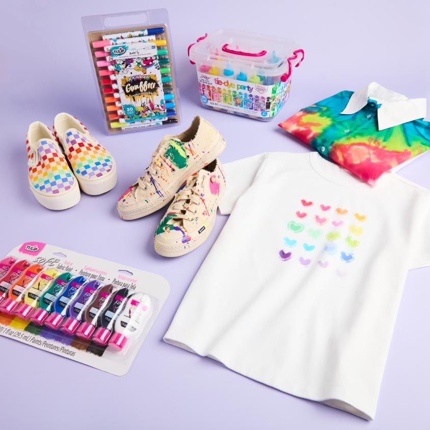 Four rainbow-colored projects (2 shoes & 2 shirts) with fabric paints, markers and tie dye on a purple background.